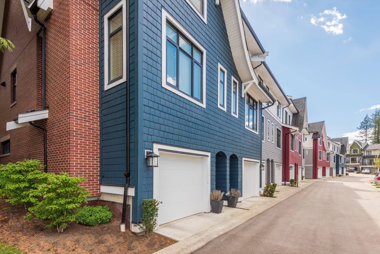 Row of homes with blue, white and red siding and painted trim