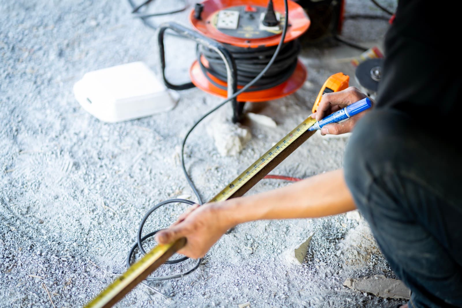 Worker measuring and marking a window opening for repair