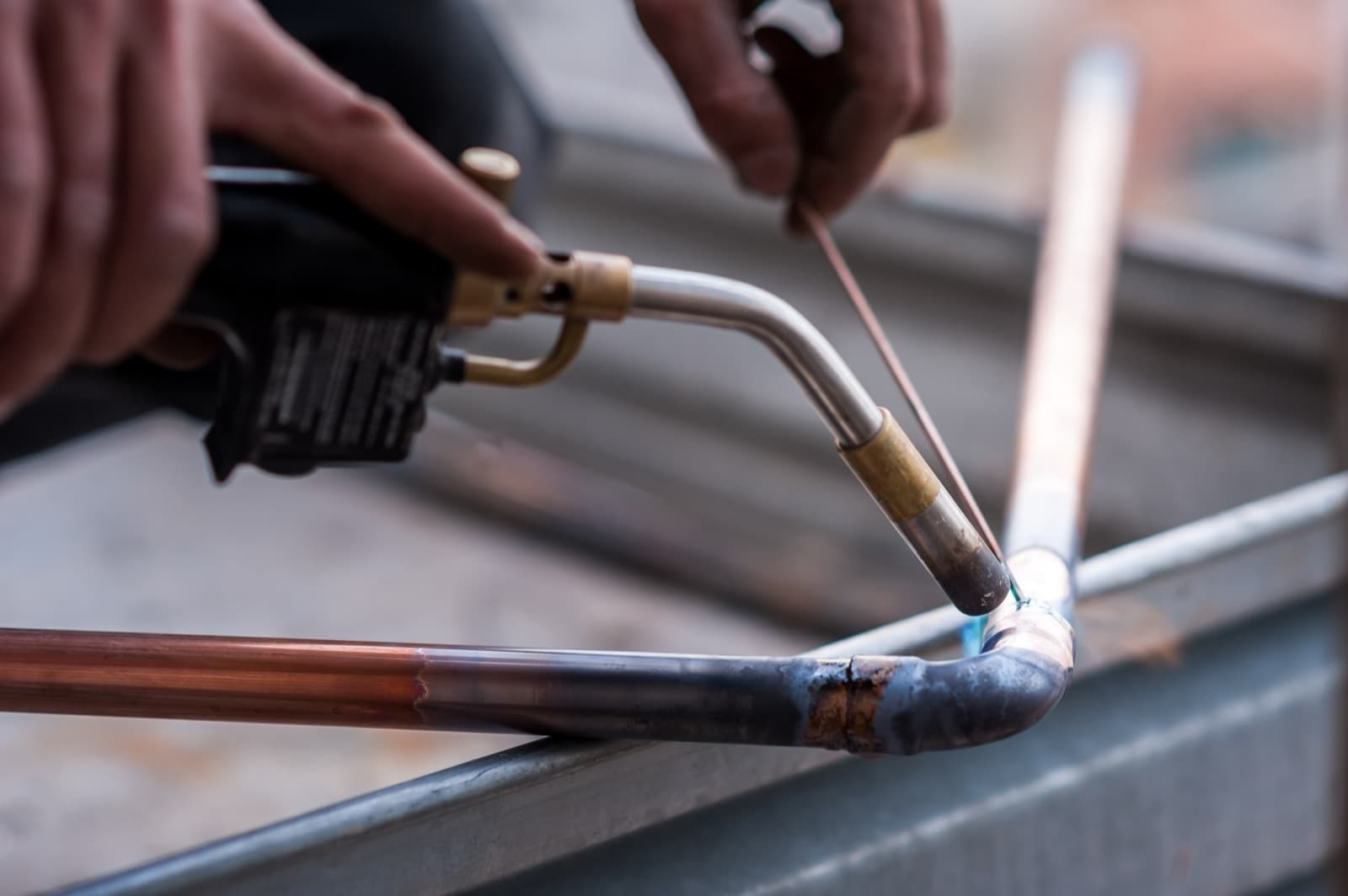 Plumber soldering copper pipe during a repipe in an older home