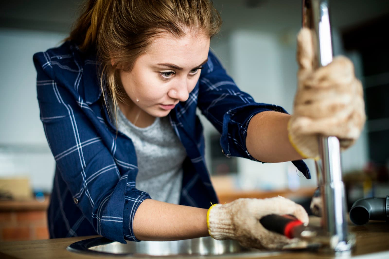 Plumber working on sink plumbing in an Addison home