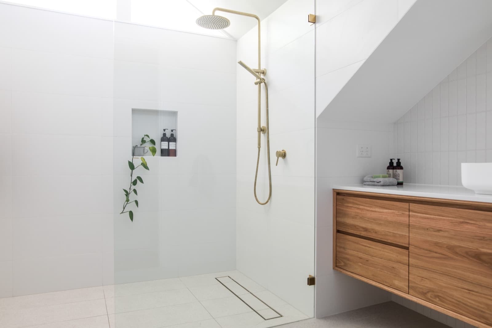 Bathroom design inspiration with a glass shower, brass fixtures and a wood vanity