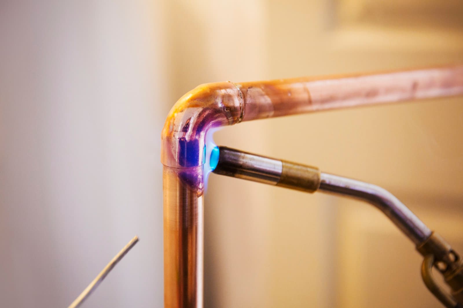 Close-up of a copper pipe being welded during a whole-home repipe