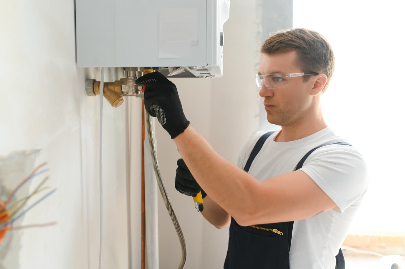Licensed plumber working on a water heater
