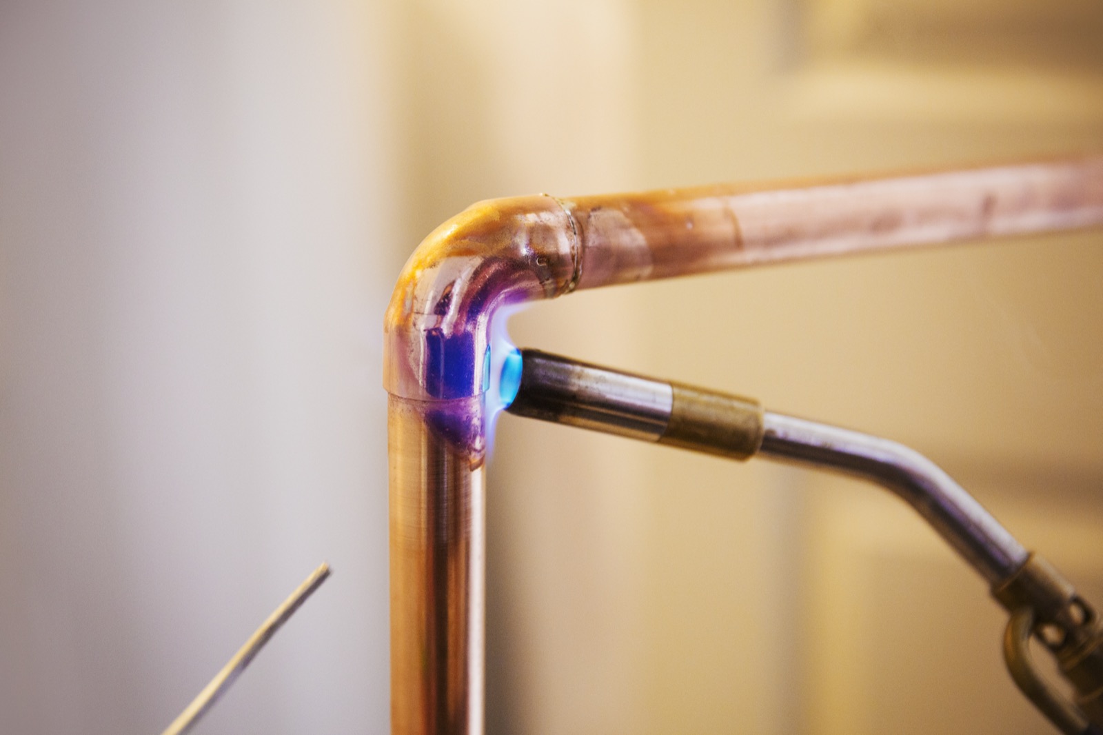 Close-up of a copper pipe being welded during a whole-home repipe