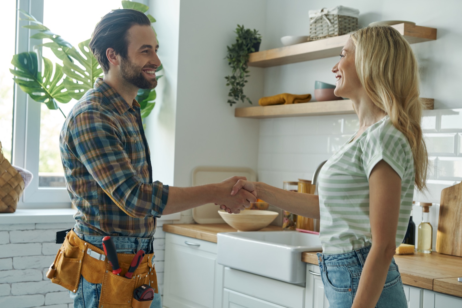 Homeowner and technician shaking hands after agreeing on a flat-rate price