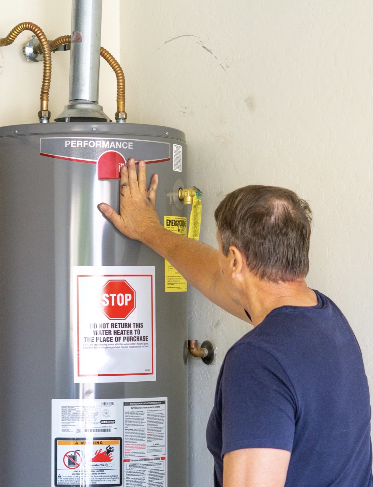 Technician inspecting a water heater during a free plumbing safety check